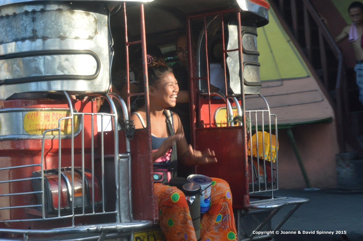 A young Filipina busking on the back of a Jeepny in Manila in 2015